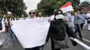 Demonstran perempuan menunjukkan spanduk saat aksi damai di Jalan Medan Merdeka Selatan, Jumat (4/11). Ratusan ribu massa aksi damai melakukan aksi menuntut penegakan hukum kasus dugaan penistaan agama. (Liputan6.com/Yoppy Renato)
