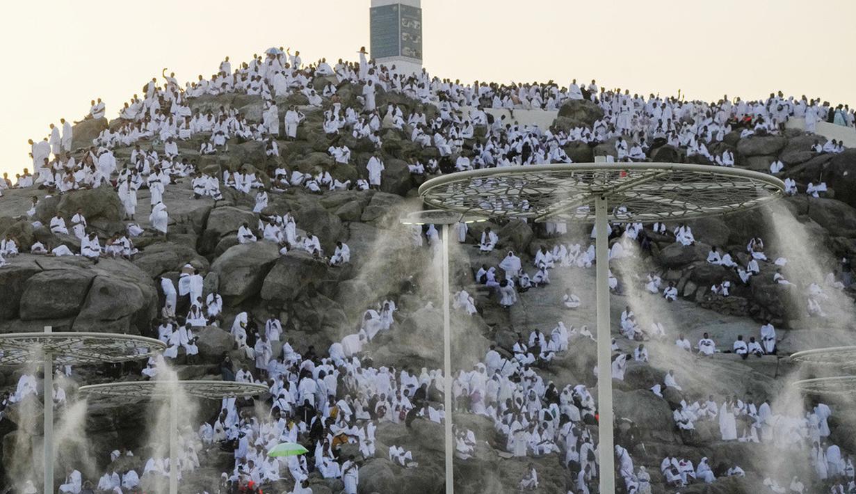 Kabut air disemprotkan ke jemaah haji saat mereka berdoa di bukit berbatu yang dikenal sebagai Gunung Rahmat di Dataran Arafah selama ibadah haji tahunan dekat Kota Suci Makkah, Arab Saudi, Selasa (27/6/2023). Sekitar dua juta jemaah berkumpul di Kota Suci Makkah untuk haji terbesar sejak pandemi virus corona COVID-19 yang sangat membatasi akses ke salah satu dari lima rukun Islam tersebut. (AP Photo/Amr Nabil)