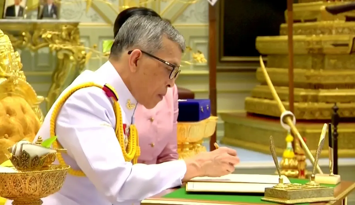 Raja Maha Vajiralongkorn menandatangani dokumen pernikahannya dengan Ratu Suthida saat melangsungkan prosesi pernikahan di Bangkok, Thailand, Rabu (1/5/2019). Raja Maha Vajiralongkorn yang kini berusia 66 tahun resmi menikahi Ratu Suthida yang berusia 40 tahun. (Thai TV Pool via Reuters)