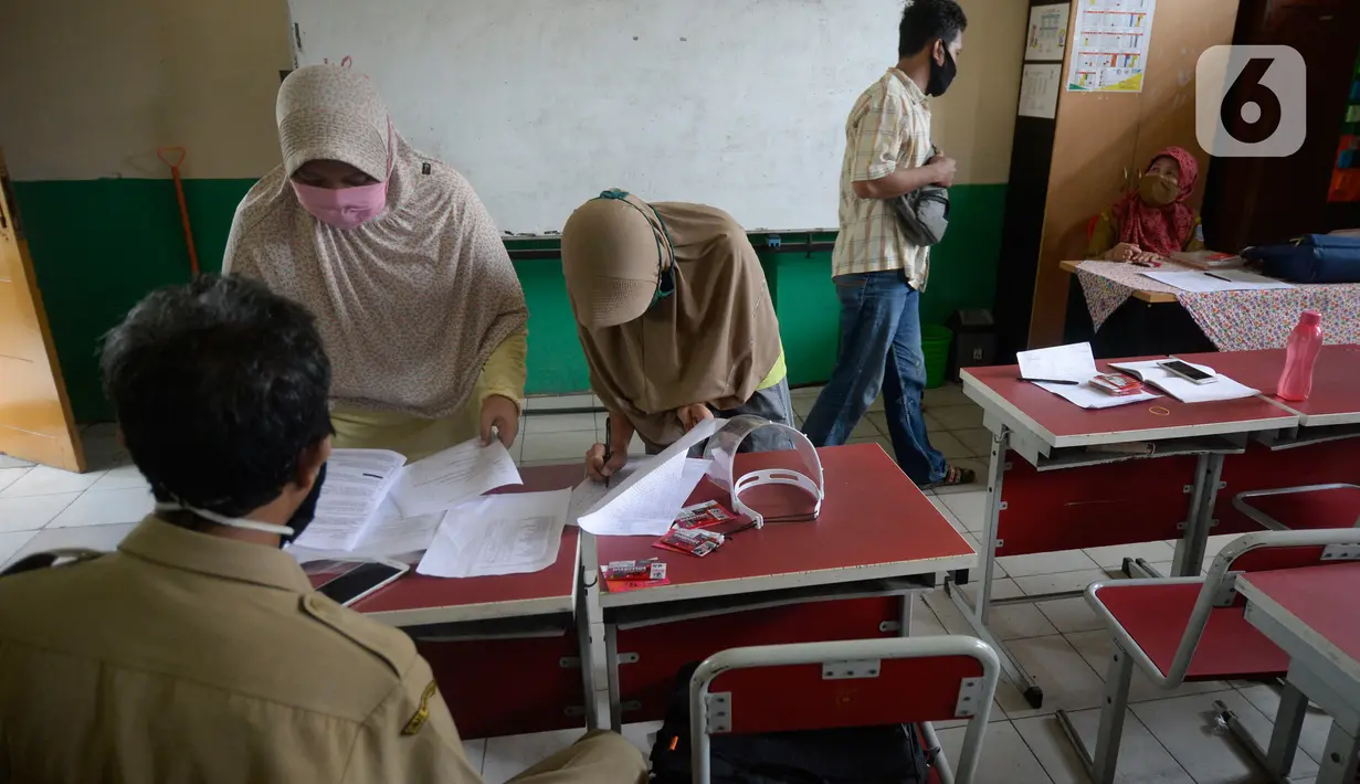 Wali murid menerima dua kartu perdana Tri dan Telkomsel beserta kuota gratis di SDN Serua Indah I dan II, Ciputat, Tangerang Selatan, Senin (15/9/2020). Program Kartu Perdana tersebut untuk mendukung kegiatan belajar secara online di masa pandemi covid-19. (merdeka.com/Dwi Narwoko)