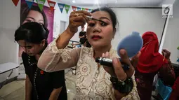 Seorang pengemudi ojek online wanita memakai maskara saat kelas kecantikan jelang peragaan busana di Rawamangun, Jakarta, Jumat (20/4). Kegiatan menyambut Hari Kartini tersebut diikuti puluhan ojek online wanita. (Liputan6.com/Fery Pradolo)