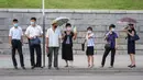 Komuter menunggu bus saat suhu tinggi mencapai 34 derajat celsius di Pyongyang, Korea Utara, Rabu (21/7/2021). Musim Panas dimulai pada bulan Juni hingga Agustus, dan puncak musim panas adalah bulan Agustus. (KIM Won Jin / AFP)