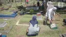 Sejumlah umat muslim menaburkan bunga di makam keluarganya di Tempat Pemakaman Umum (TPU) Karet Tengsin, Jakarta, Minggu (27/3/2022). Sepekan jelang datangnya bulan suci Ramadan, banyak warga yang melakukan tradisi ziarah makam untuk mendoakan keluarganya. (Liputan6.com/Faizal Fanani)