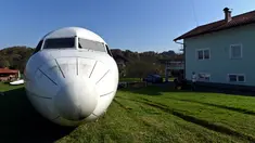 Badan pesawat Fokker-100 terlihat diparkir di halaman rumah warga setempat di Strmec Stubicki, dekat Zagreb, Kroasia, 26 Oktober 2019. Robert Sedlar (50) mengubahnya menjadi objek wisata di mana pesawat bisa disewakan untuk semua jenis acara dan pesta. (Denis LOVROVIC/AFP)
