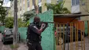 Seorang polisi militer melakukan operasi penggerebekan di daerah kumuh Cidade de Deus di Rio de Janeiro, Brasil (1/2). Daerah Cidade de Deus dikenal sebagai kampungnya para gembong dan penyelundup narkotika. (AFP Photo/Mauro Pimentel)
