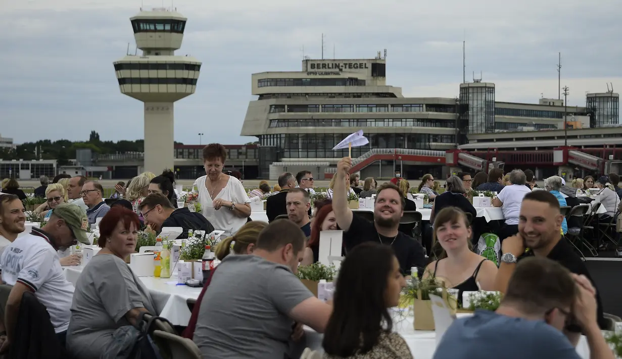 Orang-orang mengikuti acara“Berlin Freedom Dinner” di landasan pacu bekas bandara Tegel, Berlin pada 7 Agustus 2021. Acara yang dihadiri sekitar 3.000 warga tersebut untuk mengirim sinyal 'Berlin kembali!' setelah berbulan-bulan menghadapi pandemi COVID-19. (Tobias SCHWARZ/AFP)