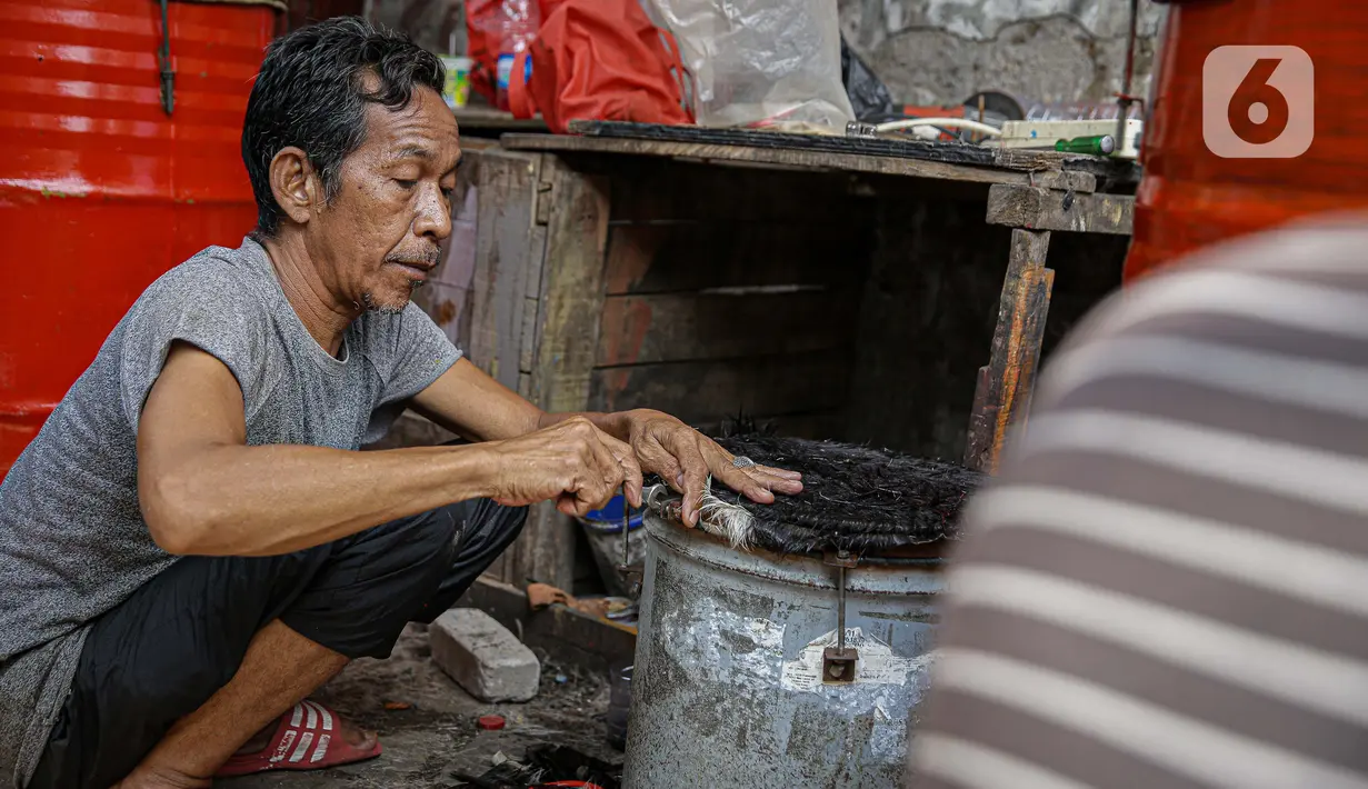 Pekerja menyelesaikan pembuatan bedug di jalan KH Mas Mansyur, Tanah Abang, Jakarta, Senin (10/6/2021). Menjelang Idul Fitri 1442 H, pedagang bedug di sepanjang jalan itu mulai ramai menjajakan dagangannya dari harga 40 ribu hingga Rp 2,5 juta. (Liputan6.com/Faizal Fanani)