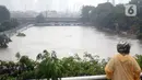 Warga melihat-lihat kondisi Banjir Kanal Barat di Kawasan Tanah Abang, Jakarta, Rabu (1/1/2020). Hujan yang mengguyur Jakarta sejak Selasa sore (31/12/2019) mengakibatkan debit air Banjir Kanal Barat tinggi dan hampir meluap. (Liputan6.com/Helmi Fithriansyah)