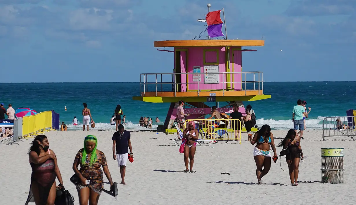 Orang-orang menikmati suasana pantai di Miami, Florida pada Selasa (16/3/2021). Mahasiswa telah tiba di daerah Florida Selatan untuk liburan musim semi tahunan. Para pejabat kota prihatin dengan kerumunan liburan musim semi saat pandemi COVID-19 terus berlanjut. (Joe Raedle/Getty Images/AFP)