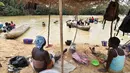 Penambang emas wanita berisitirahat di sungai Pampana di dekat Mekeni, sebelah utara Sierra Leone (5/3). Melintasi tanah yang curam, ratusan pria dan wanita di sungai menyaring kerikil, memisahkan bintik-bintik emas dari lumpur. (AFP Photo/Issouf Sanogo)