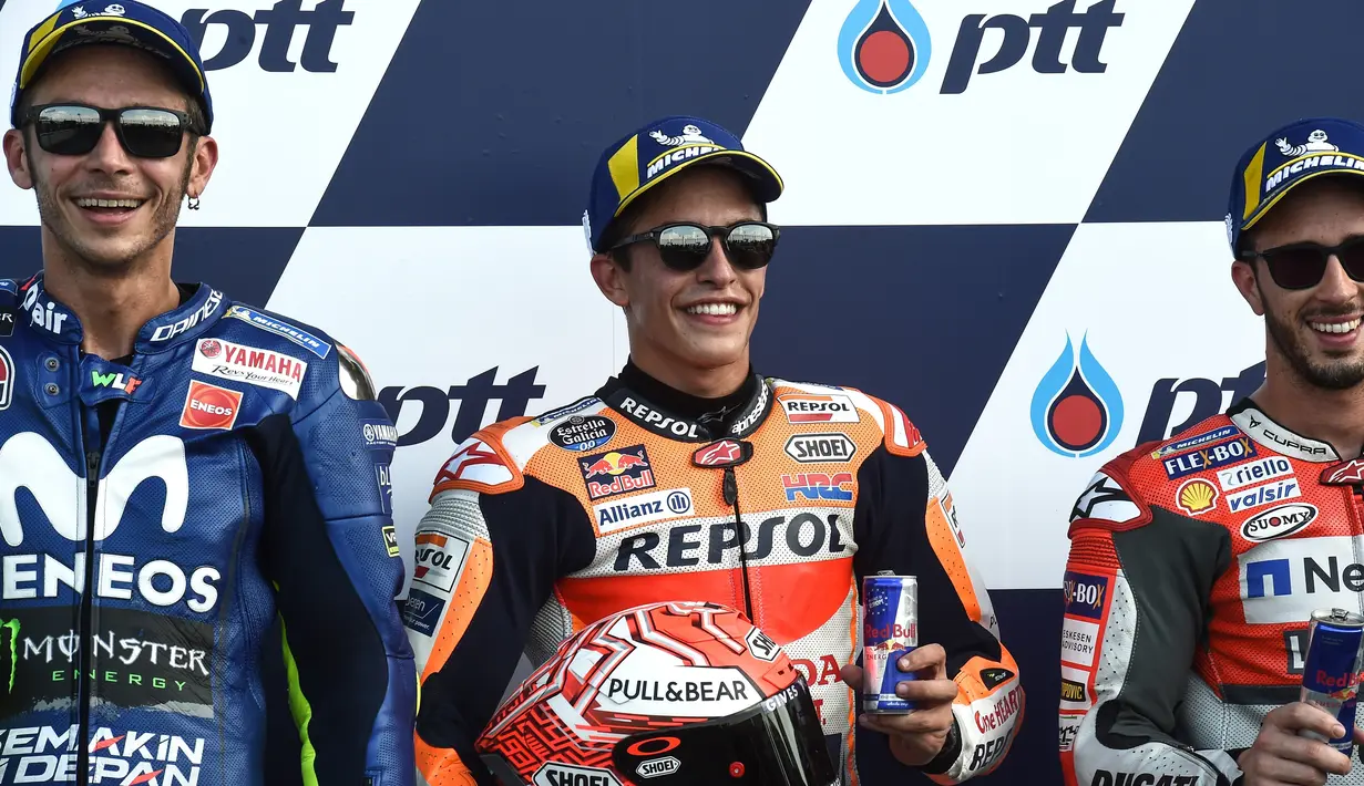 Pebalap Marc Marquez, Valentino Rossi dan Andrea Dovizioso berpose bersama usai mengikuti kualifikasi MotoGP Thailand 2018 di Sirkuit Internasional Buriram (6/10). Rossi berada di posisi kedua dengan catatan waktu 1.30.099. (AFP Photo/Lillian Suwanrmpha)