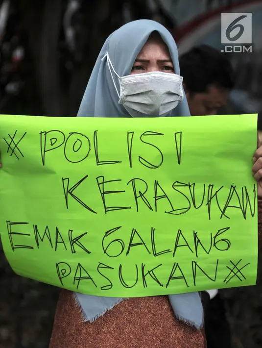 Kaum ibu yang tergabung dalam Emak-Emak Indonesia membentangkan poster saat aksi di depan Gedung Polda Metro Jaya, Jakarta, Minggu (29/9/2019). Mereka juga menuntut Presiden Jokowi untuk menghentikan intimidasi serta kriminalisasi pejuang demokrasi. (merdeka.com/Iqbal S. Nugroho)
