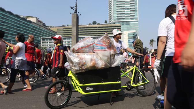 Relawan membawa karung berisi sampah plastik saat gerakan bersih sampah plastik di kawasan Car Free Day, Jakarta, Minggu (21/10). Gerakan itu untuk meningkatkan kesadaran masyarakat mengenai ancaman sampah plastik bagi Bumi. (Liputan6.com/Angga Yuniar)