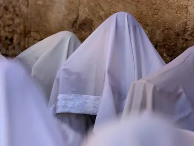 Umat Yahudi memanjatkan doa saat memperingati Hari Raya Sukkot di Tembok Barat, Kota Tua Yerusalem, 22 September 2021. Sukkot adalah hari raya untuk memperingati eksodus bangsa Israel dari Mesir sekitar 3200 tahun yang lalu. (Emmanuel DUNAND/AFP)