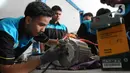 Pelajar SMK Negeri 26 Jakarta melakukan pengecekan instalasi part konversi mobil listrik di Bengkel Otomotif SMKN 26, Jakarta, Rabu (13/5/2023). (merdeka.com/Imam Buhori)