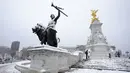 Salju menutupi Queen Victoria Memorial di Istana Buckingham di London, Senin (10/12/2022). Salju dan es telah menyapu sebagian Inggris, dengan suhu dingin dan kabut yang membekukan serta salju diperkirakan akan tetap ada sepanjang minggu ini. (AP Photo/Kirsty Wigglesworth)