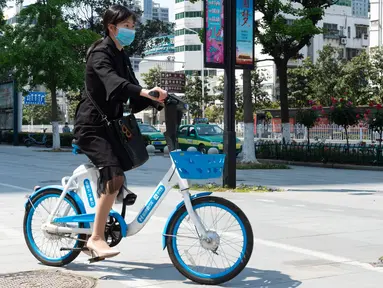 Warga mengendarai sepeda listrik untuk layanan berbagi kendaraan di Distrik Fancheng di Kota Xiangyang, Provinsi Hubei, China tengah (24/4/2020). Seiring meredanya pandemi COVID-19, perusahaan-perusahaan layanan berbagi sepeda di kota tersebut bertahap memulai kembali bisnisnya. (Xinhua/Xie Jianfei)