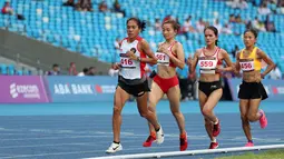 Reaksi pelari putri Indonesia, Odekta Elvina Naibaho (kiri) berkompetisi pada nomor lari 10.000 meter SEA Games 2023 di Stadion Morodok Techo National Stadium, Phnom Penh, Kamboja, Jumat (12/5/2023). Odekta meraih medali perunggu dengan catatan waktu 35 menit 31,03 detik sementara medali emas dan perak direbut dua atlet Vietnam, Thi Oanh Nguyen (35 menit 11,53 detik) dan Thi Hong Le Pham (35 menit 21,09 detik). (Bola.com/Abdul Aziz)