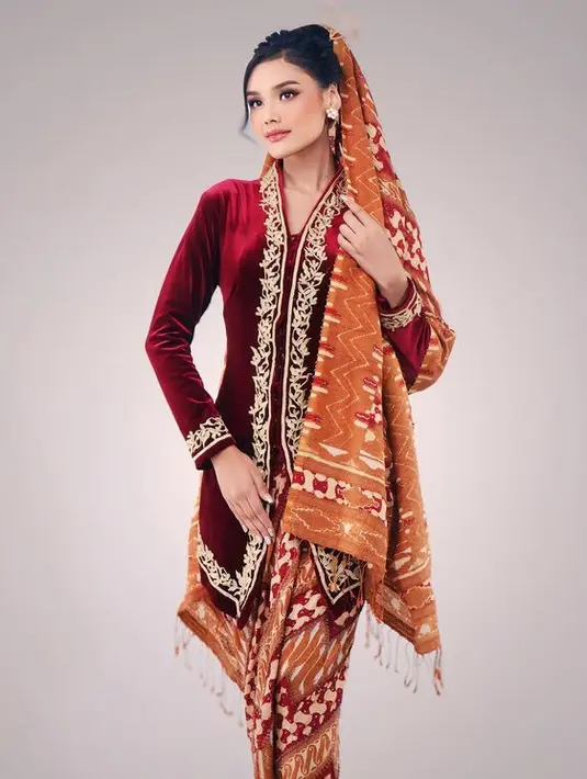Memiliki tinggi badan 173 cm, Tata begitu memesona mengenakan kebaya velvet maroon dengan aksen bordiran keemasan dipadukan kain warna coral.  [@harashtata]