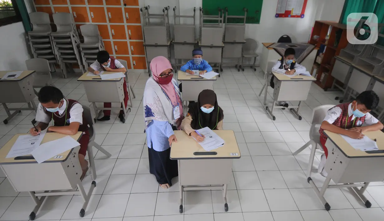 Guru mangawasi murid saat kegiatan  KSN  seleksi Tingkat SD/ MI Kecamatan Cinere  mata pelajaran IPA di SDIT MU, Depok, jawa Barat, Sabtu (6/3/2021). Sebelumnya dilaksanakan secara virtual akibat pandemi covid-19. (merdeka.com/Arie Basuki)