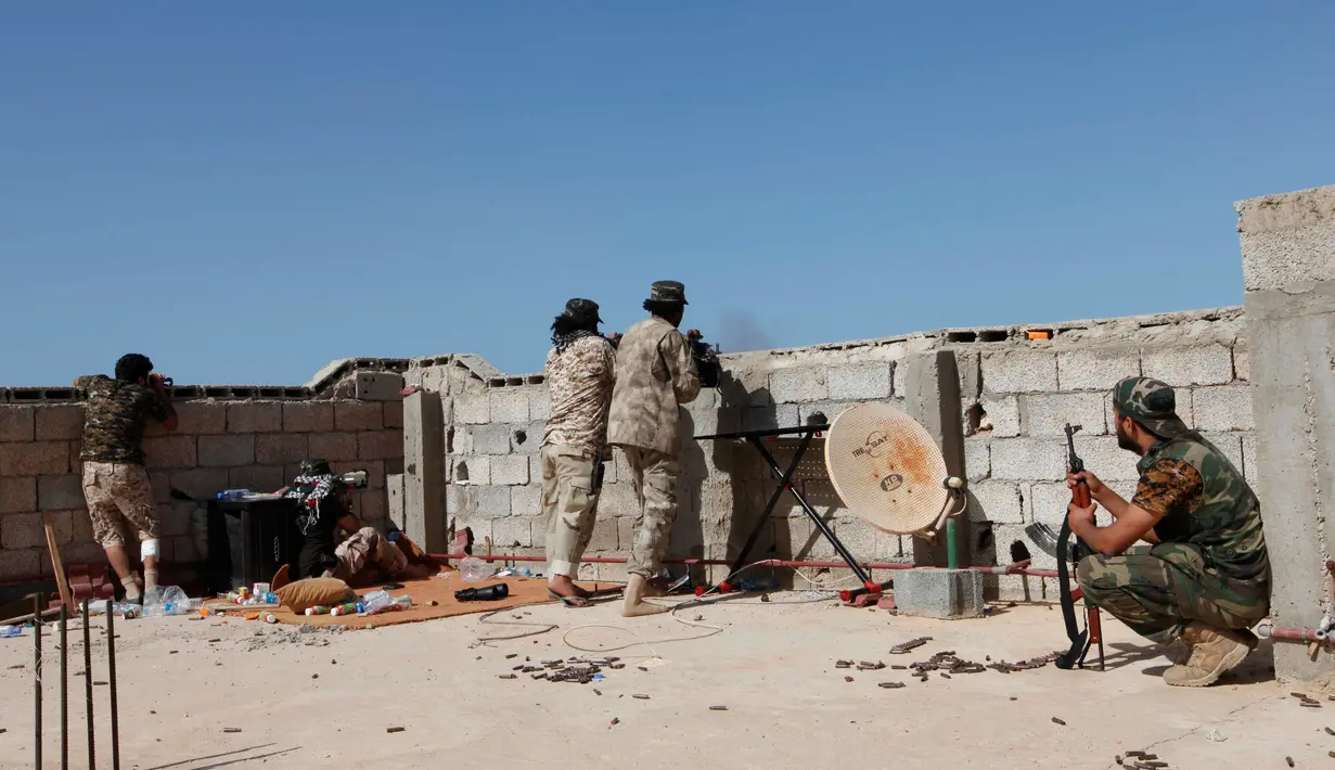 Para pasukan militer pemerintah Libya melepaskan tembakan dari lubang beton saat melakukan serangan kepada para pejuang ISIS dari atap atap rumah di daerah Zaafran, di Sirte, Libya, 30 Juni 2016. (REUTERS/Ismail Zitouni)