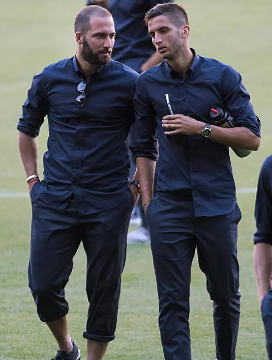 Penyerang Juventus, Gonzalo Higuain (kiri) berbincang denga gelandang Rodrigo Betancur di lapangan stadion Camp Nou di Barcelona, (11/9). Juventus akan menghadapi Barcelona pada laga pertama penyisihan grup D Liga Champions. (AFP Photo/Jaime Reina)
