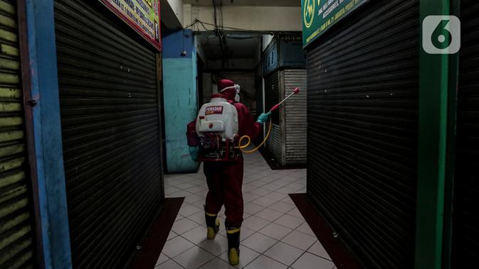 Petugas menyemprotkan Cairan Disinfektan di Pasar Palmerah, Jakarta, Kamis (25/6/2020). Penyemprotan dilakukan guna mencegah dan memutuskan mata rantai penyebaran Covid-19 di Area pasar Palmerah. (Liputan6.com/Johan Tallo)