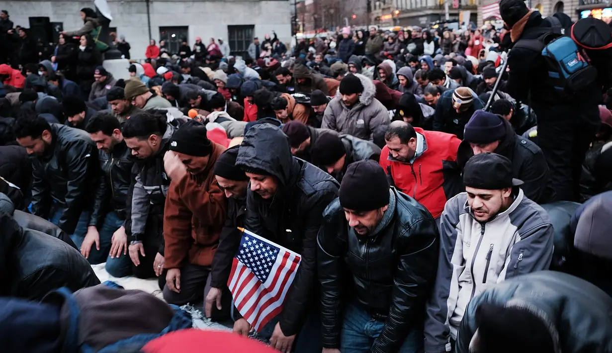 Ratusan pengunjuk rasa melakukan salat berjamaah di New York, AS (2/2). Unjuk rasa dilakukan karena adanya perintah eksekutif Donald Trump yang melarang imigran dan pengungsi dari tujuh negara mayoritas muslim. (Spencer Platt / Getty Images / AFP)