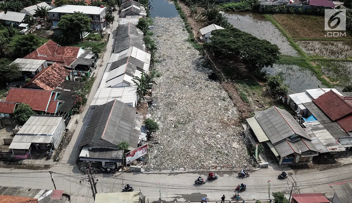 Pantauan dari udara, sampah yang menutupi Kali Pisang Batu, Tarumajaya, Kabupaten Bekasi, Rabu (9/1). Memasuki hari keempat dua alat berat dan puluhan truk dikerahkan untuk mengeruk sampah sekitar 300 ton yang sudah diangkut. (Liputan6.com/Fery Pradolo)