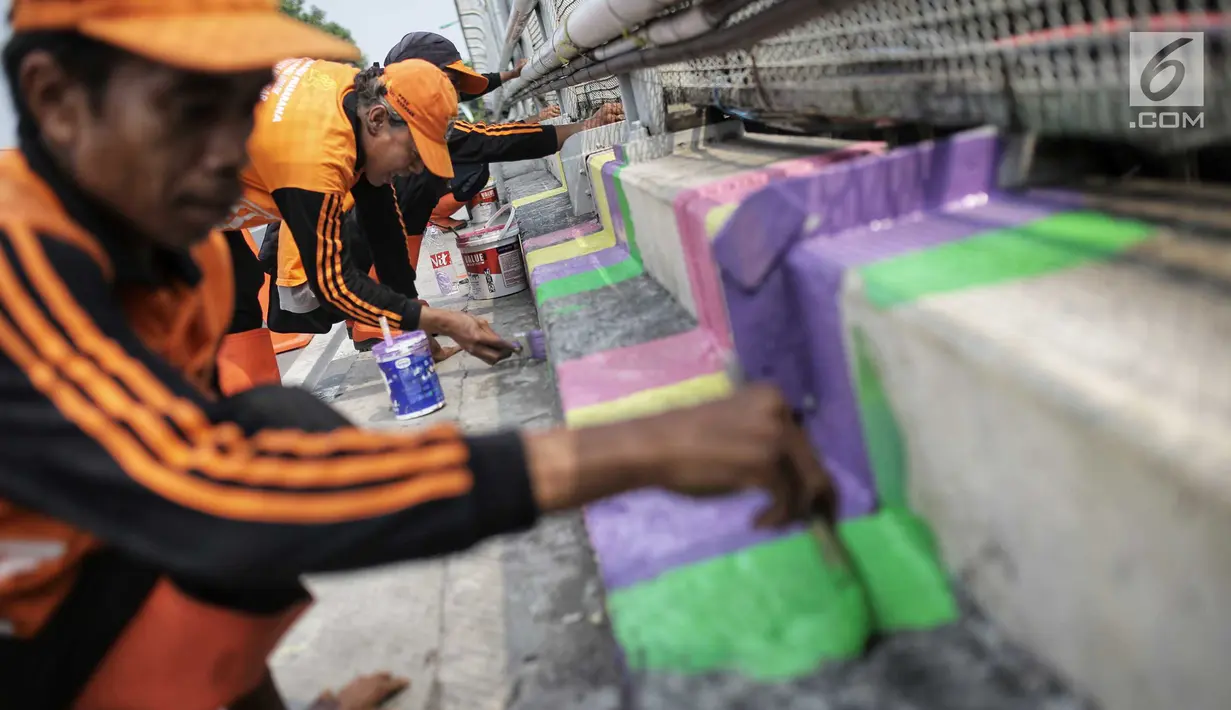 Pasukan oranye atau PPSU menyelesaikan pengecatan warna-warni jembatan layang di kampung Makasar, Jakarta, Kamis (26/7).  Pengecatan dilakukan guna mempercantik dan menyambut Asian Games 2018 pada bulan Agustus mendatang.  (Liputan6.com/Faizal Fanani)