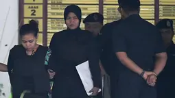 Petugas mengawal tersangka Siti Aisyah asal Indonesia (kiri) menjalani sidang di Pengadilan Tinggi Shah Alam, Kuala Lumpur, Malaysia (2/10). Kim Jong-nam terbunuh pada 13 Februari 2017 di Kuala Lumpur International Airport. (AFP Photo/Mohd Rasfan)