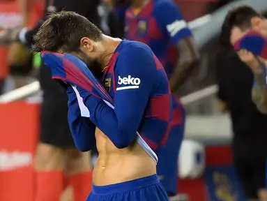 Pemain Barcelona, Lionel Messi dan Gerard Pique, tampak kecewa usai dikalahkan Osasuna pada laga lanjutan La Liga pekan ke-37 di Camp Nou, Jumat (17/7/2020) dini hari WIB. Barcelona kalah 1-2 atas Osasuna. (AFP/Lluis Gene)