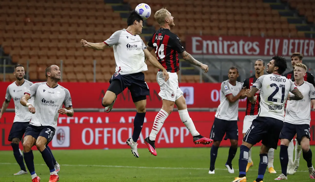 Pemain AC Milan Simon Kjaer (kanan) berebut bola udara dengan pemain Bologna Takehiro Tomiyasu pada pertandingan Serie A di Stadion San Siro, Milan, Italia, Senin (21/9/2020). AC Milan menaklukkan Bologna 2-0. (AP Photo/Antonio Calanni)
