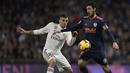 Gelandang Real Madrid, Daniel Ceballos, berebut bola dengan gelandang Valencia, Daniel Parejo, pada laga La Liga di Stadion Santiago Bernabeu, Madrid, Sabtu (1/12). Madrid menang 2-0 atas Valencia. (AFP/Oscar Del Pozo)