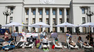 Sejumlah aktivis melakukan aksi di depan gedung parlemen Kiev, Ukraina, (12/7). Mereka menuntut para anggota parlemen untuk bekerja dan menyelesaikan tugas mereka dengan cepat bukannya mengundur waktu. (REUTERS / Valentyn Ogirenko)