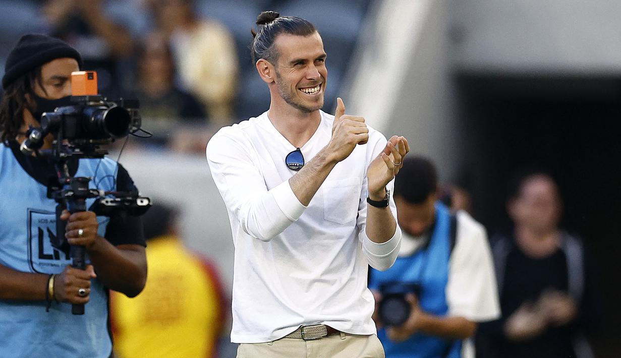 Gareth Bale menyapa para fans sebelum laga MLS 2022/2023 antara Los Angeles FC menghadapi Los Angeles Galaxy di California Stadium, Los Angeles (8/7/2022). Sayap kanan Wales yang baru saja memutuskan pensiun pada 9 Januari 2023 bersama Los Angeles FC ini memiliki hobi lain di luar sepak bola yaitu golf. Dalam beberapa kesempatan saat bertanding atau berlatih, ia kerap memperagakan beberapa gerakan cabor golf, seperti saat berselebrasi setelah mencetak gol. Kabarnya ia memang akan menggeluti golf setelah memutuskan pensiun. (AFP/Getty Images/Ronald Martinez)