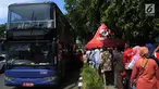 Antrean warga menaiki bus tingkat untuk wisata keliling Ibu Kota di depan Masjid Istiqlal, Jakarta, Sabtu (31/3). Libur tiga hari di penghujung Maret 2018 dimanfaatkan untuk berkeliling Jakarta menggunakan bus tingkat City Tour. (Merdeka.com/Imam Buhori)