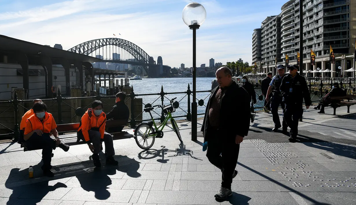 Orang-orang terlihat dengan dan tanpa masker di Circular Quay, Sydney, Selasa (6/7/2021). PM negara bagian New South Wales Gladys Berejiklian mengutarakan pihaknya akan memutuskan apakah akan memperpanjang lockdown di Sydney atau tidak yang harusnya berakhir pada 9 Juli 2021. (Bianca De Marchi/AFP)
