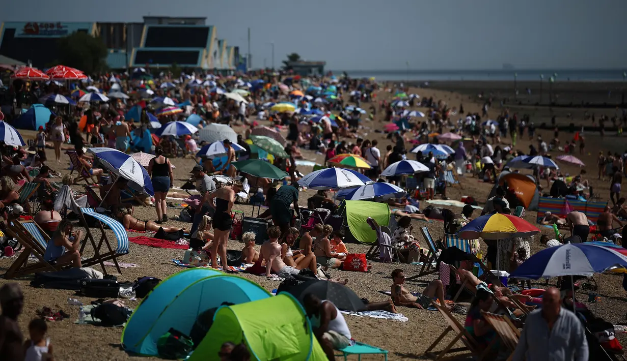 Orang-orang bersantai di kawasan Southend-on-Sea, bagian tenggara Inggris pada 12 Agustus 2024. (HENRY NICHOLLS/AFP)