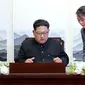 Kim Jong-un sedang menandatangani sebuah buku tamu dengan didampingi adiknya Kim Yo-jong. (AP)