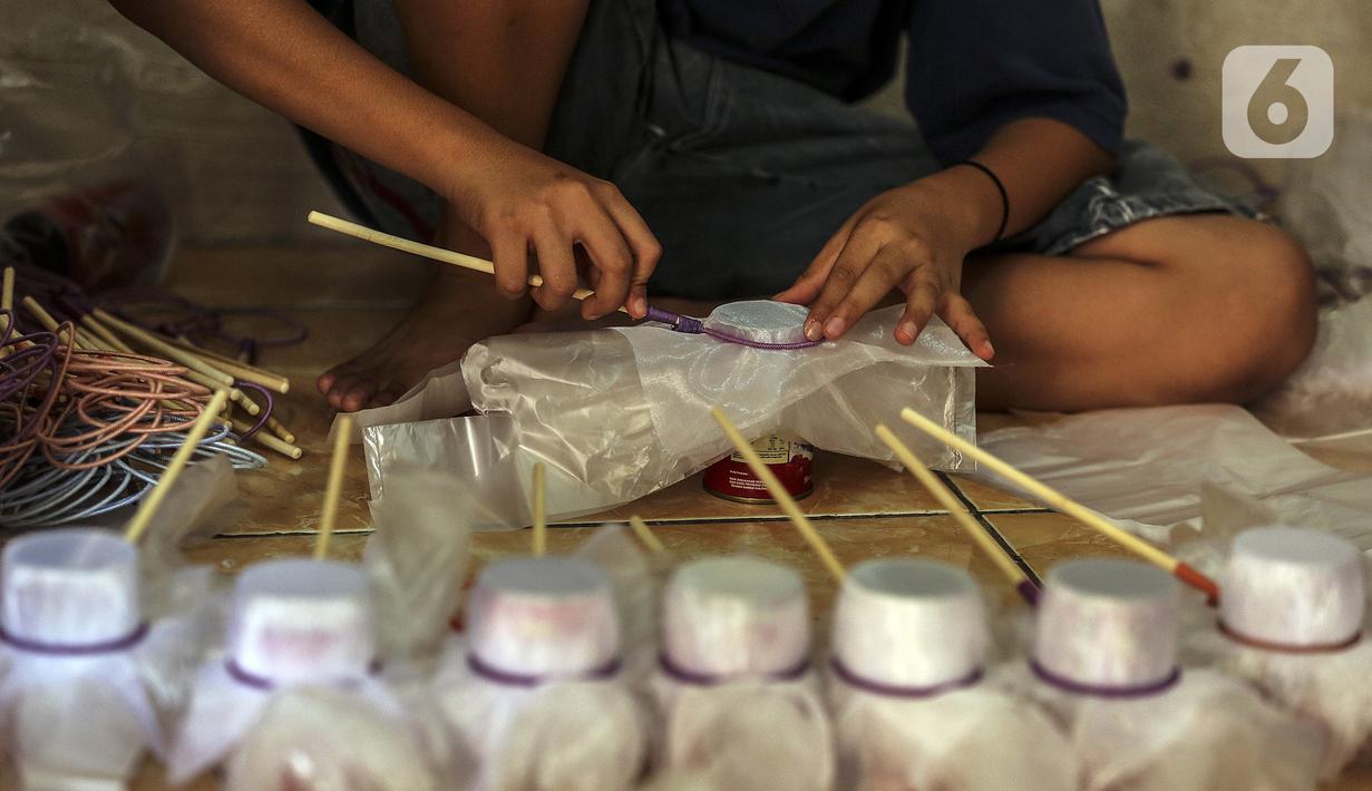 Seorang anak membuat serokan ikan cupang di rumah kontrakan Udin, Sukabumi Selatan, Jakarta Barat, Selasa (22/12/2020). Anak-anak membantu membuat serokan ikan cupang setelah tugas sekolah selesai. (Liputan6.com/Johan Tallo)
