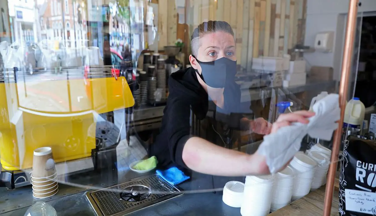 Pegawai bekerja di sebuah kedai kopi di London, Inggris, Minggu (17/5/2020). Beberapa restoran, kafe, dan toko katering di Inggris secara bertahap kembali buka setelah pemerintah melonggarkan kebijakan lockdown akibat virus corona COVID-19. (Xinhua/Tim Ireland)