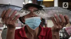 Pedagang menunjukan ikan bandeng di Pasar Petak Sembilan, Glodok, Jakarta, Senin (31/1/2022). Ikan bandeng banyak dibeli jelang Imlek sebagai hidangan saat perayaan Tahun Baru masyarakat Tionghoa itu. (Liputan6.com/Faizal Fanani)