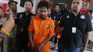 Pelaku pembunuhan wartawan Abdullah Fitri Setiawan yang tewas dalam drum M Nurhadi digiring petugas di Bogor di Polda Metro Jaya, Jakarta, Rabu (21/11). Kedua pelaku dijerat pasal pembunuhan berencana dan terancam hukuman mati. (Merdeka.com/Imam Buhori)