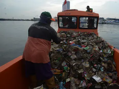 Petugas dari Dinas Lingkungan Hidup DKI Jakarta mengangkut sampah di Pelabuhan Kali Adem, Muara Angke, Jakarta, Rabu (6/1/2021). Dalam sehari, sampah pesisir Teluk Jakarta Utara bisa terangkut sekitar 7 kubik sampah plastik yang terbawa dari sungai maupun arus laut. (merdeka.com/Imam Buhori)