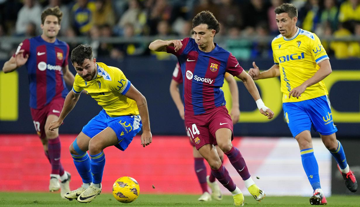 Pemain Barcelona, Joao Felix, berusaha melewati pemain cadiz pada laga pekan ke-31 La Liga 2023/2024, di Stadion Nuevo Mirandilla, Minggu (14/4/2024). (AP Photo/Jose Breton)