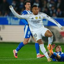Pemain Real Madrid, Kylian Mbappe, mencoba lepas dari penjagaan bek Deportivo Alaves saat kedua tim bertarung dalam lanjutan Liga Spanyol 2025/2025, Senin (15/12/2025) dini hari WIB. (AP Photo/Miguel Oses)