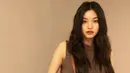 Kim Doyeon mengenakan atasan sleeveless bernuansa cokelat, senada dengan tas Celine yang dibawanya. Ia memadukan penampilannya dengan celana hitam. Foto: Document/Celine.