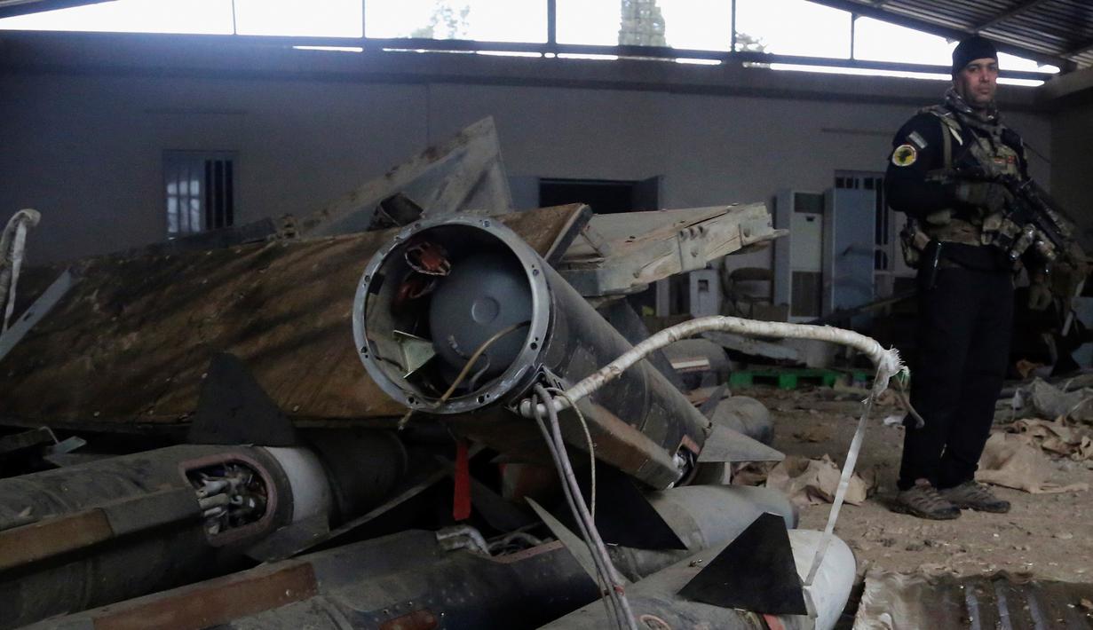 Pasukan khusus Irak memeriksa rudal yang ditemukan di sebuah gudang senjata milik ISIS di sisi timur Mosul, Sabtu (28/1). Gudang senjata tersebut ditemukan setelah pasukan Irak membebaskan wilayah timur Mosul dari militan ISIS. (AP Photo/Khalid Mohammed)