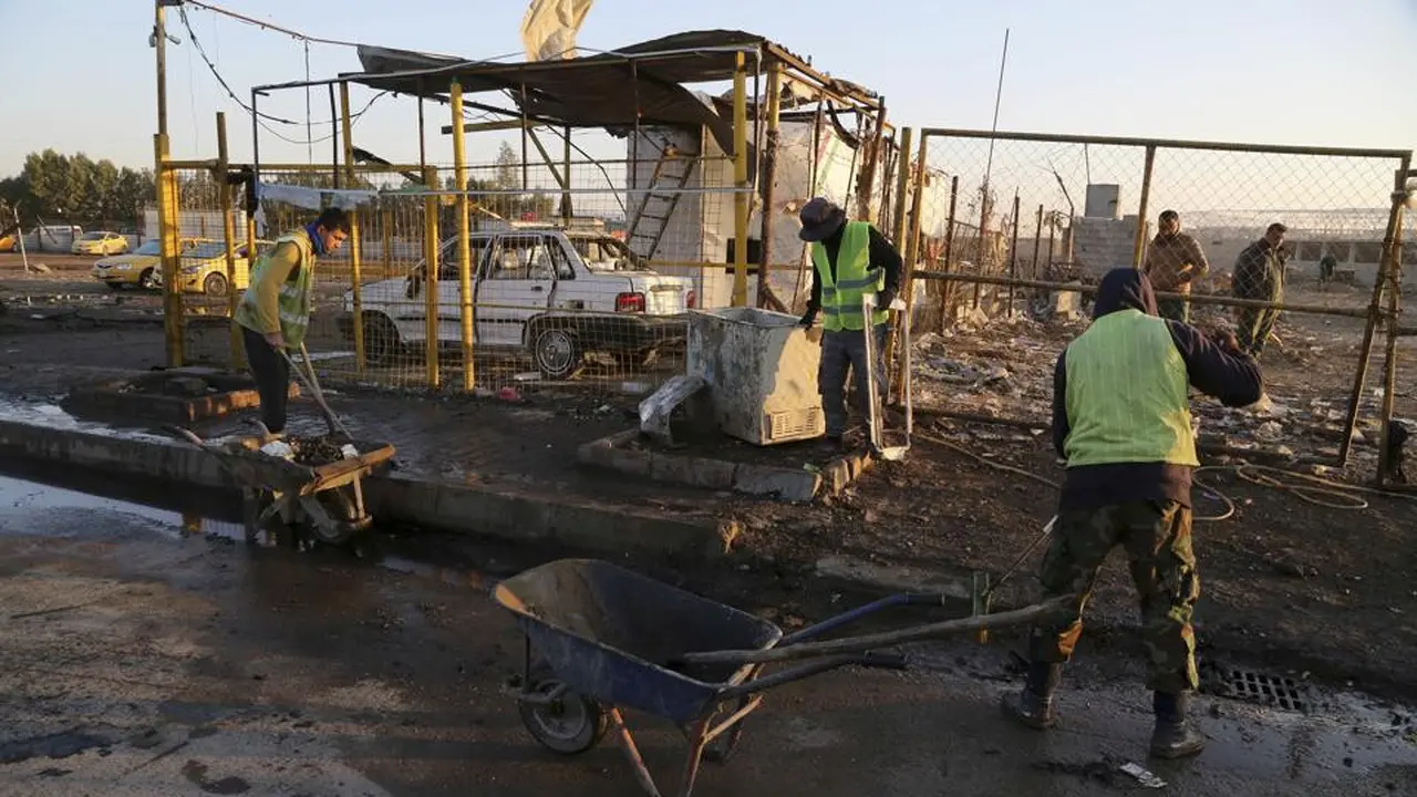 Petugas tengah membersihkan sisa ledakan bom mobil di Bayaa, Baghdad, Irak. (AP)